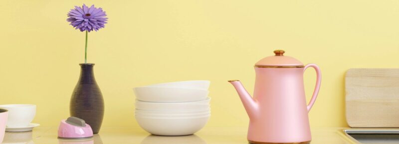 a yellow wall with various kitchen utensils on it