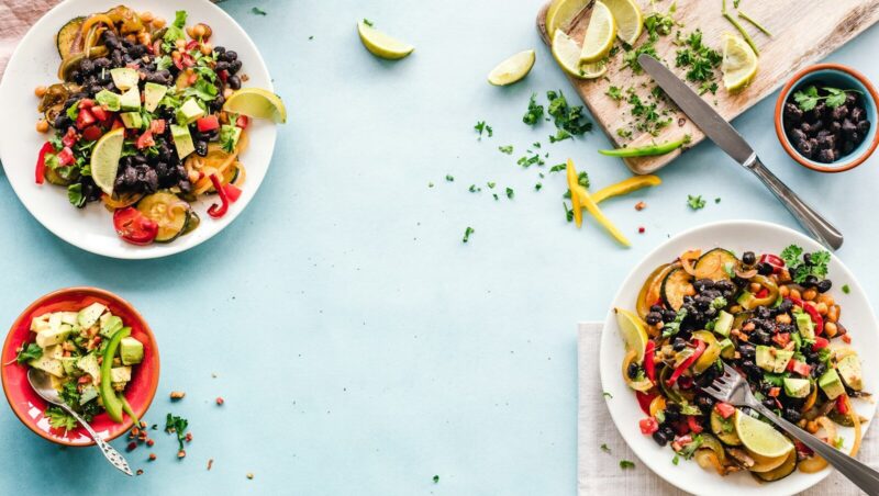 three bowls of salad dish with lemon on table