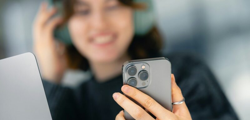 A woman looking at her cell phone while sitting at a table